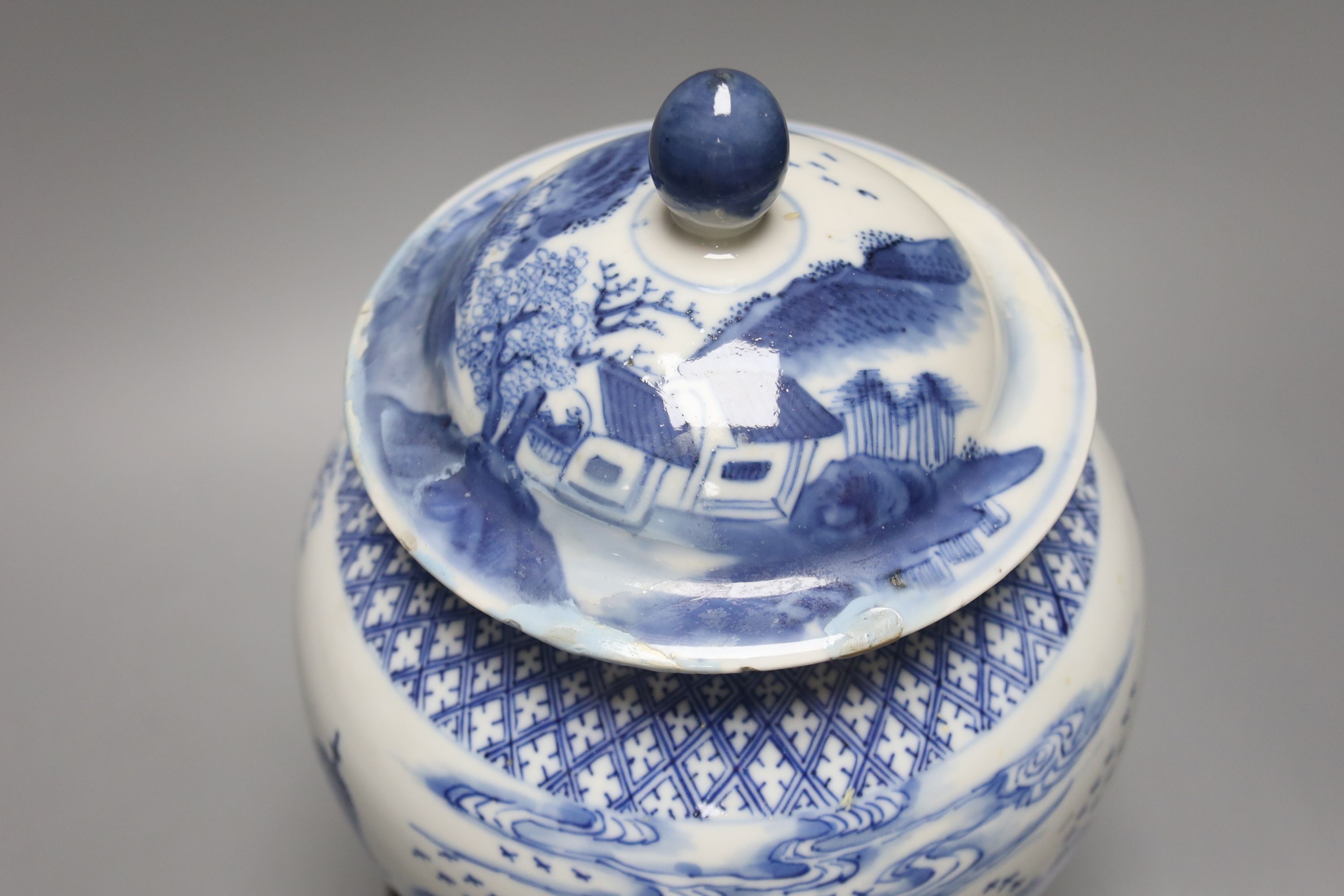 A late 19th / early 20th century Chinese blue and white landscape jar and cover, wood stand 30cm total height